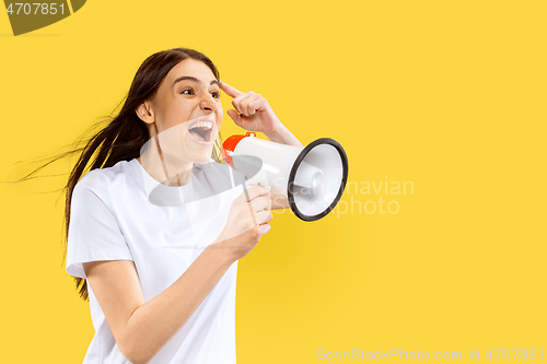 Image of Portrait of beautiful woman isolated on yellow studio background