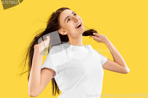 Image of Portrait of beautiful woman isolated on yellow studio background