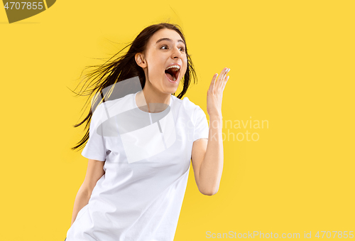 Image of Portrait of beautiful woman isolated on yellow studio background