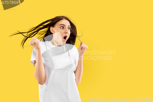 Image of Portrait of beautiful woman isolated on yellow studio background