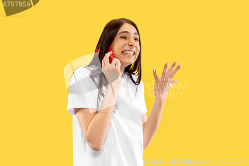 Image of Portrait of beautiful woman isolated on yellow studio background