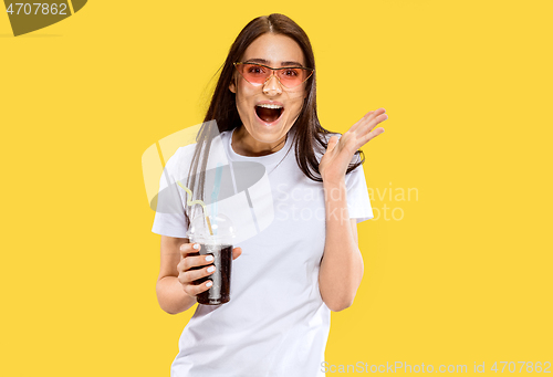 Image of Portrait of beautiful woman isolated on yellow studio background