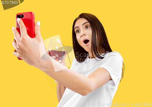 Image of Portrait of beautiful woman isolated on yellow studio background