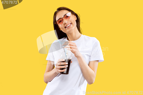 Image of Portrait of beautiful woman isolated on yellow studio background