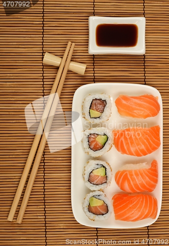 Image of chopsticks, soy sauce and sushi on the bamboo mat