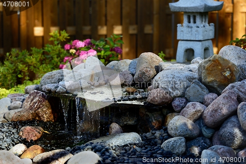 Image of traditional Japanese garden with a stone pagoda and a waterfall