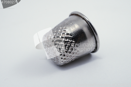 Image of old metal tailor thimbles on a white 