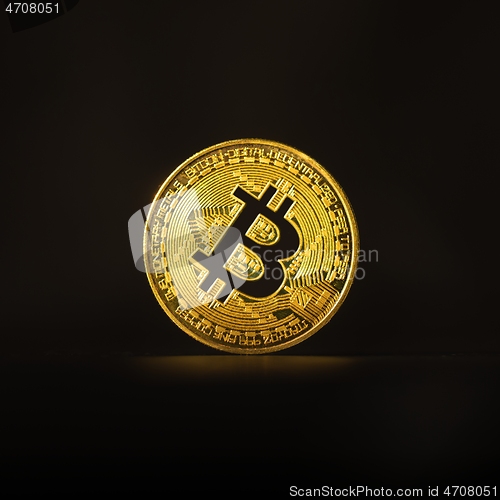 Image of Physical shiny bitcoin agains dark background