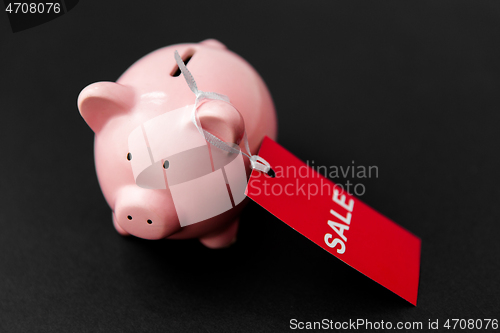 Image of piggy bank with red sale tag on black