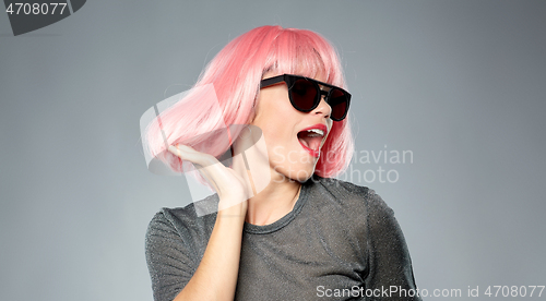 Image of happy woman in pink wig and sunglasses dancing