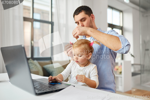 Image of working father with baby daughter at home office