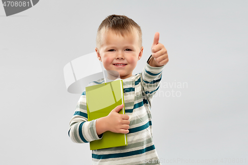 Image of portrait of smiling boy holding book