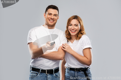 Image of happy couple with tv remote control