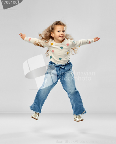 Image of smiling little girl jumping
