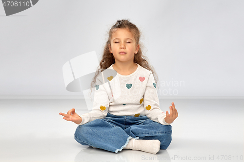 Image of little girl in yoga lotus pose and meditating
