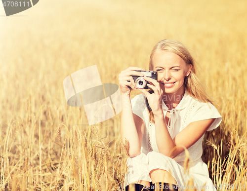 Image of happy woman with film camera in wreath of flowers