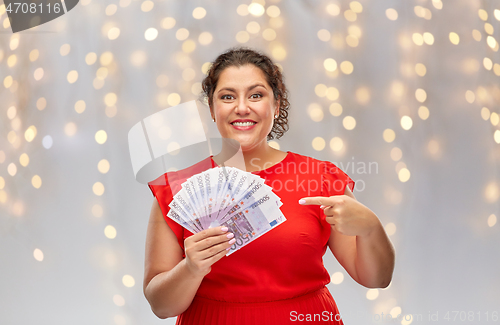 Image of happy woman showing euro money banknotes