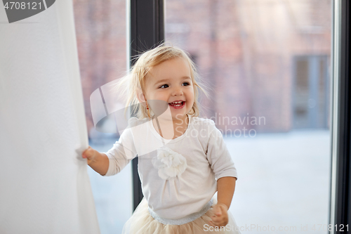 Image of happy smiling baby girl at home window