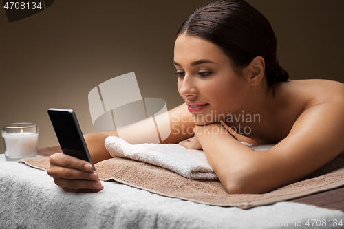 Image of woman with smartphone at spa or massage parlor