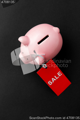 Image of piggy bank with red sale tag on black