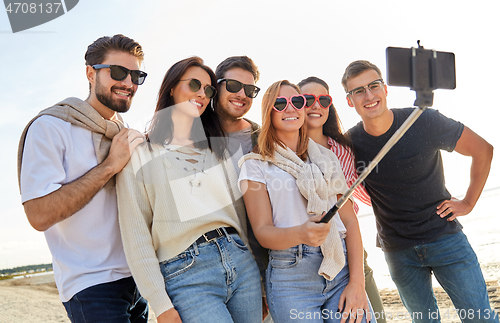 Image of happy friends taking selfie on summer beach