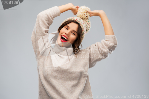 Image of young woman in knitted winter hat and sweater