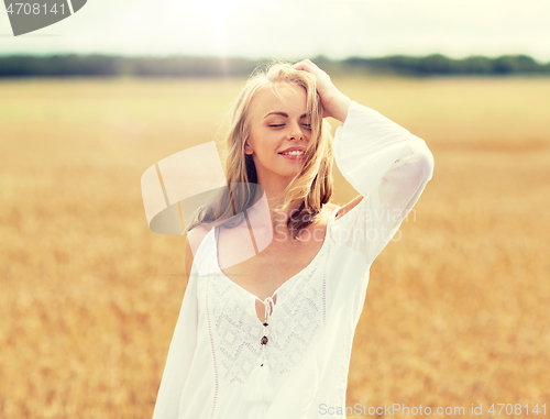 Image of smiling young woman in white dress on cereal field