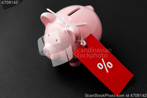 Image of piggy bank with red sale tag on black