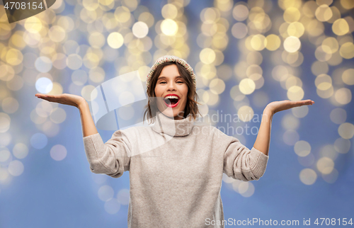 Image of woman in winter hat holding something on christmas