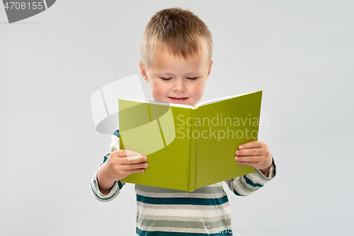 Image of portrait of smiling boy reading book