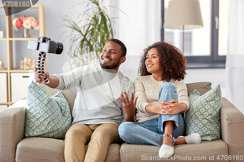 Image of couple of video bloggers with camera at home