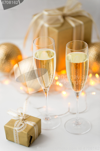 Image of glasses of champagne and christmas gifts