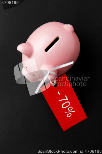 Image of piggy bank with red sale tag on black