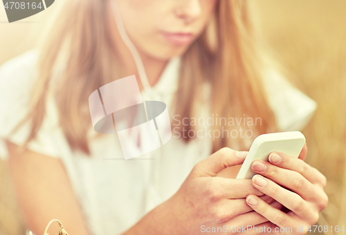 Image of close up of woman with smartphone and earphones