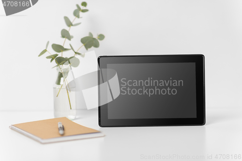 Image of tablet pc with black screen on white office table
