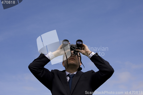 Image of Businessman looking through binoculars