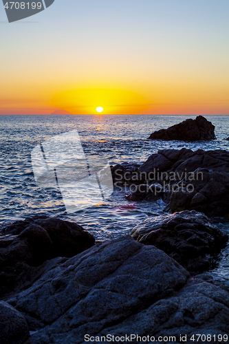 Image of Sunset on the rocky shore.