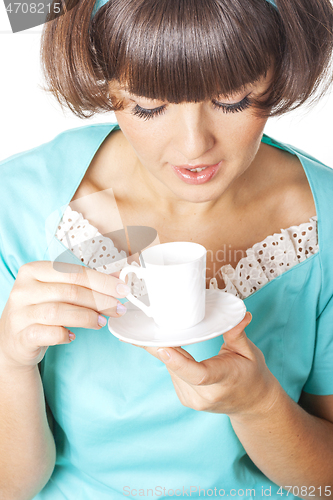 Image of Portrait of young woman in blak dress enjoying a cup of coffee.
