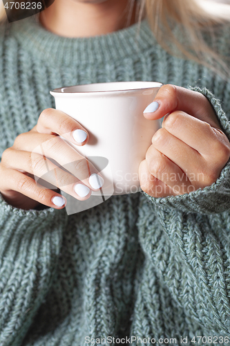 Image of Young woman relaxing tea cup on hands.