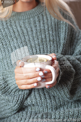 Image of Young woman relaxing tea cup on hands.