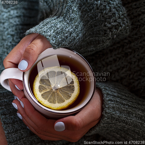 Image of Young woman relaxing tea cup on hands.