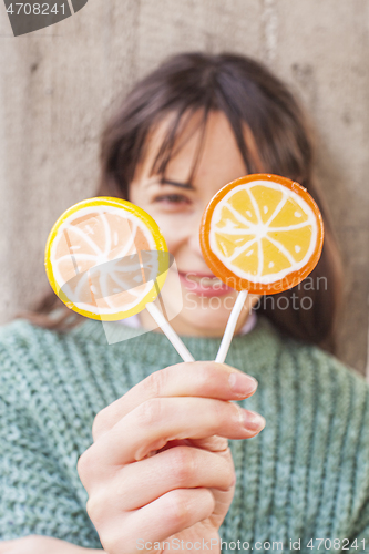 Image of Pretty young happy woman posing with sweet lollipops. 