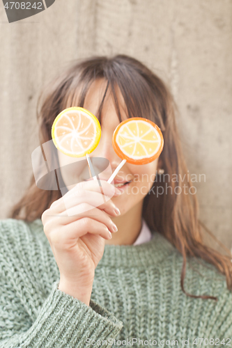 Image of Pretty young happy woman posing with sweet lollipops.