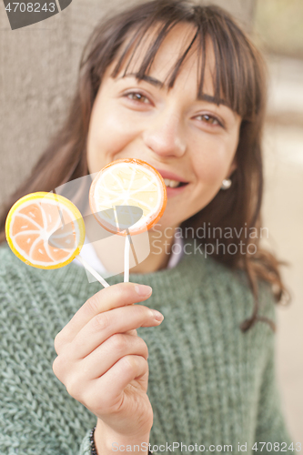 Image of Portrait of pretty young happy woman posing with sweet lollipops