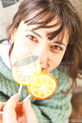 Image of Portrait of pretty young happy woman posing with sweet lollipops