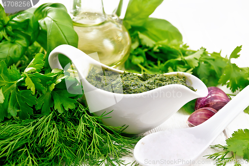 Image of Sauce of spicy greens in gravy boat on light board