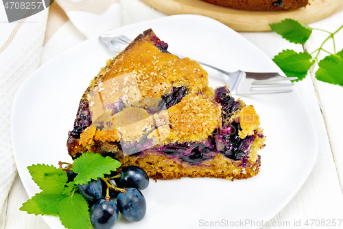 Image of Pie with black grapes  in plate on wooden board