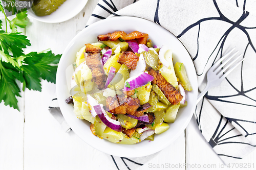 Image of Salad potato with bacon and cucumber in plate on board top