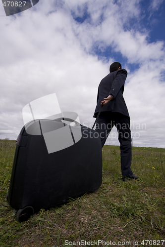 Image of businessman pushing his baggage