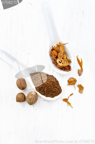 Image of Nutmeg round and mace in spoons on white board top